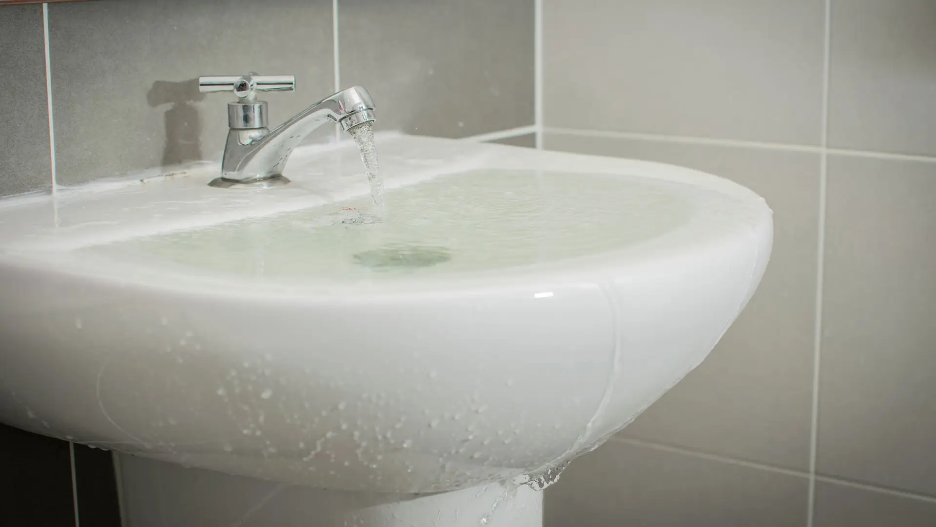 Weisses überlaufendes Waschbecken
