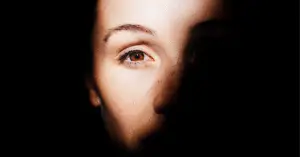 Frau über 40 mit offenem Blick halb im Schatten, schwarz-weiss